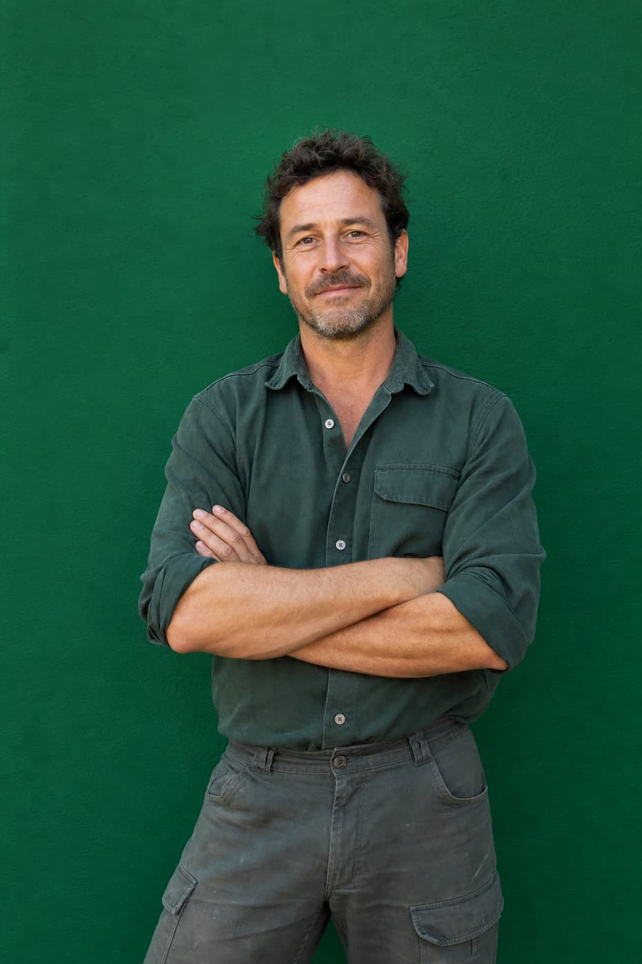 An experienced groundskeeper with arms folded